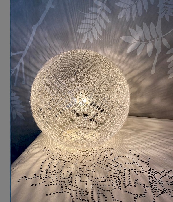 NEW - Shetland fine lace wool table lamp. Alice Maude pattern from the 1800s in Shetland white on smoked glass, reflects subtle pattern when lit. - Image